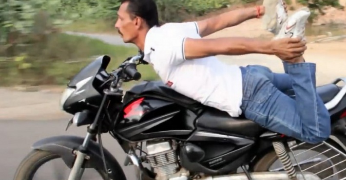 Житель Индии занимается йогой на мотоцикле. Видео