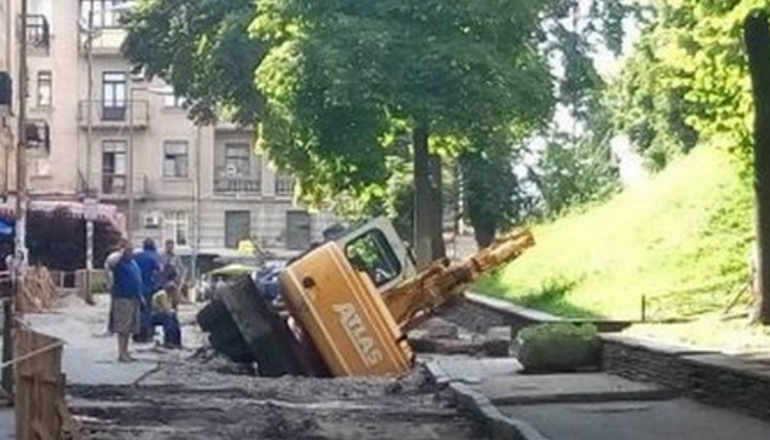 В Киеве под землю провалился экскаватор
