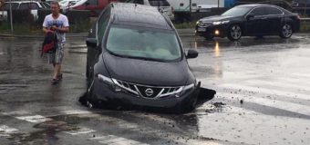 В Киеве после ливня под асфальт провалился автомобиль. Фотофакт